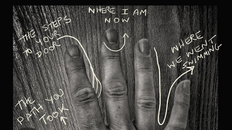 A hand photographed in black and white with text drawn on top of the image. 