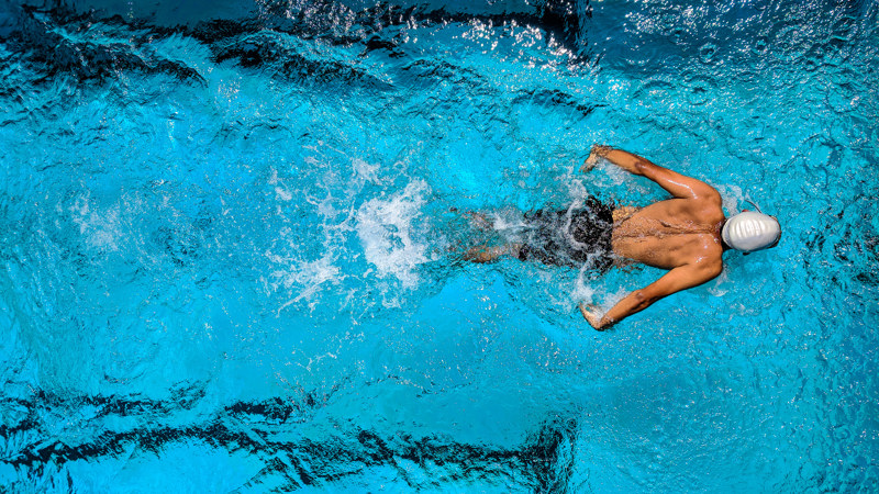 An aerial view of a man swimming in a swimming pool