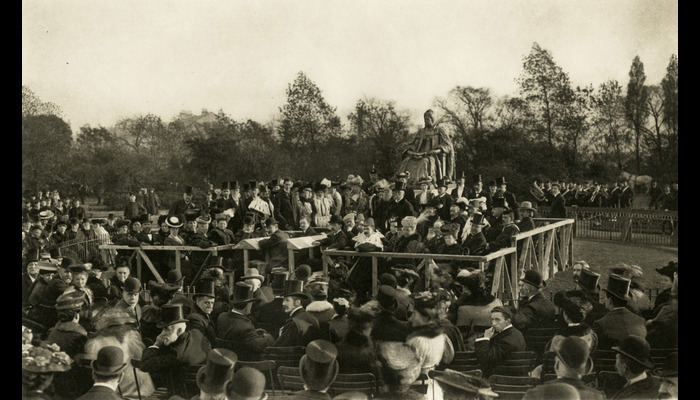 A photo of a group of people gathered around a statue