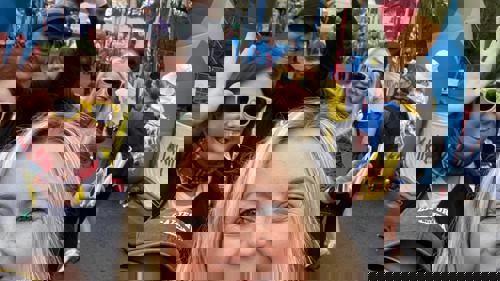 A group of six people gathered for a photo at the finish line of a charity walk event