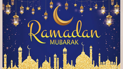 A blue and gold banner showing a city skyline, a moon and string lights and text Ramadan Mubarak