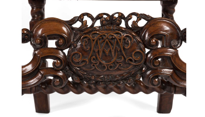 detail shot of a monogram on an ornate dark wooden chair