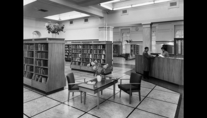 Black and white photograph of a library with shelves of books