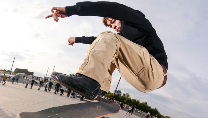 A skateboarder pulls off a stunt in a skate park