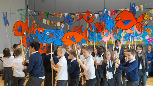 A group of school children are taking part in a protest performance. 