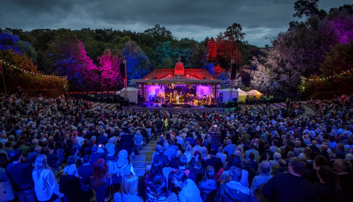 An audience enjoy a concert at a 1920s bandstand and amphitheatre