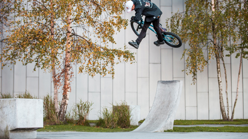 A freestyle cyclist turns in the air after riding up a ramp