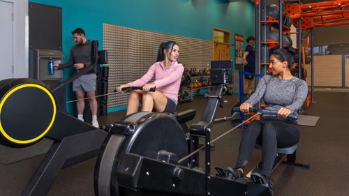 Two Glasgow Club members on rowing machines in gym
