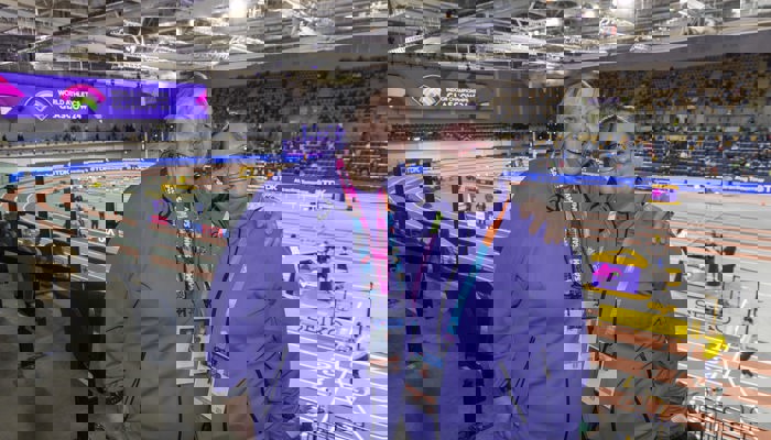 Two volunteers with their arms round each other in the stands at the Emirates Arena during the 2024 World Athletics Indoor Championships.