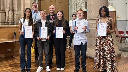 A group of young people with their certificates at a celebration event. 