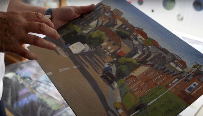 Fiona shows a painting of the local area.