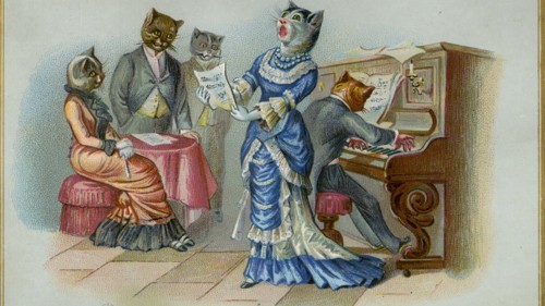 A Christmas card with a group of cats singing round a piano