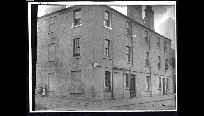 Full plate black and white glass plate negative showing an exterior view of William Simpson's birthplace, on West College Street. 