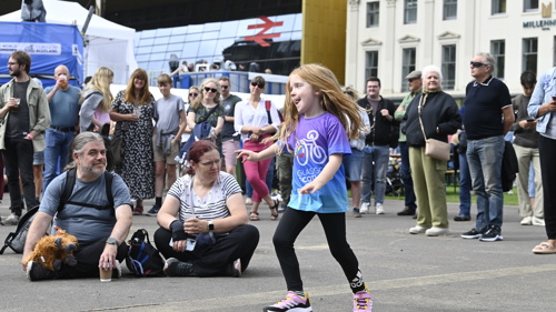 People dance and sit in George Square listening to live music. 