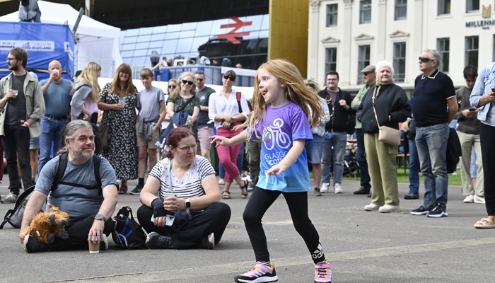 People dance and sit in George Square listening to live music. 