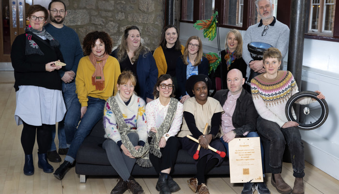 A group of artist stand and sit.