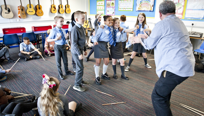 John Binnie leads an creative workshop with school pupils. The school pupils are dancing and jumping whilst John dramatises.. 